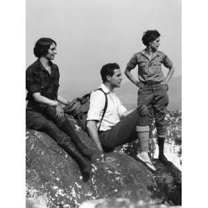 Three People in Hiking Clothes, Atop Mountain on Rock Outcrop, Looking 