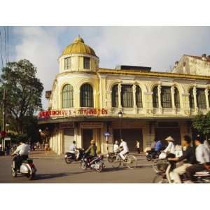  Locals Pass by an Old Colonial Building on Motorbikes in 